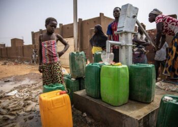 Des déplacés venus du Burkina Faso dans un camp ivoirien et en train de s’approvisionner dans en eau.
